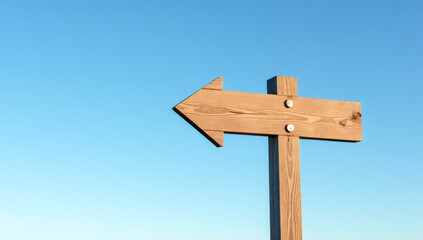 An empty wooden signpost against a blue sky background