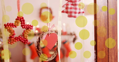 Image of yellow dots moving over window with christmas decoration