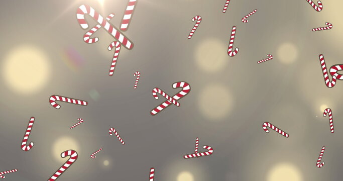 Naklejki Image of snow and christmas candy canes falling over spot lights in background
