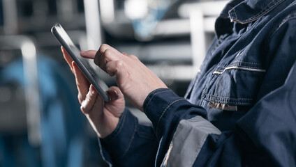 Factory worker using computer tablet in beer production facility