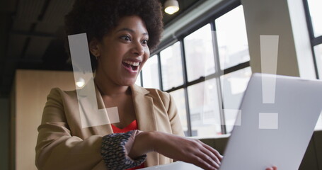 Image of lol text over african american businesswoman using laptop