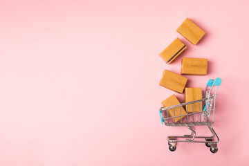 Online shopping concept.Cardboard box and shopping bags in a trolley on a bright colored...