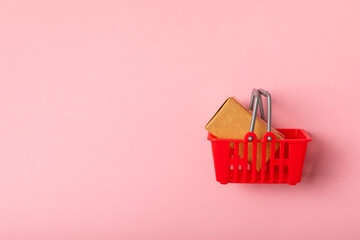 Online shopping concept.Cardboard box and shopping bags in a trolley on a bright colored...