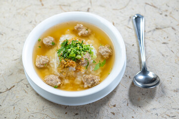 Bowl of soup with meat and vegetables sits on a table