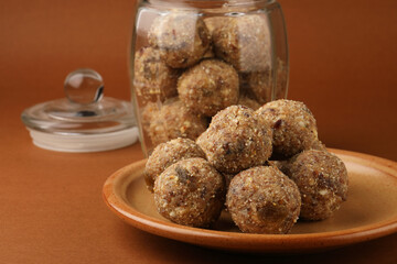 Healthy snacks, fitness lifestyle and high fiber diet concept with dates and dryfruits energy Laddus or Ladoo surrounded by dried fruits, Cashew Nuts, pistachios , almonds