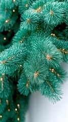 Teal artificial Christmas tree branch with warm-toned lights