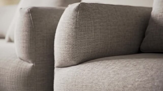Stylish Home Interior: Close-up of a modern sofa with a light gray textured fabric