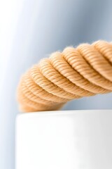 Close-up of a beige rope coiled on a white surface