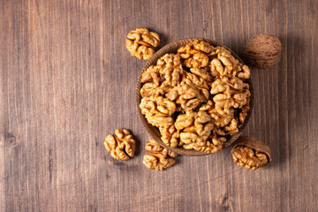 Walnuts nuts in a bowl on wooden background