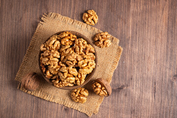 Walnuts nuts in a bowl on wooden background