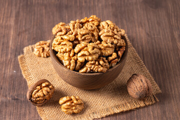 Walnuts nuts in a bowl on wooden background