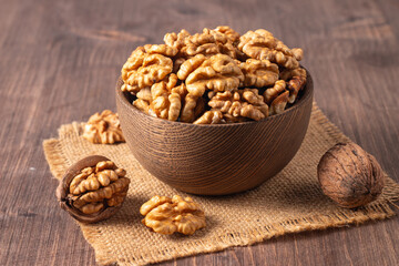 Walnuts nuts in a bowl on wooden background