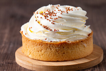 Lemon tartlets with whipped cream, sprinkles and chocolate chips on white background