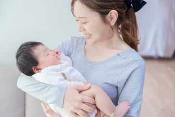 赤ちゃんを抱いて微笑む女性