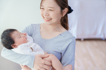 赤ちゃんを抱いて微笑む女性