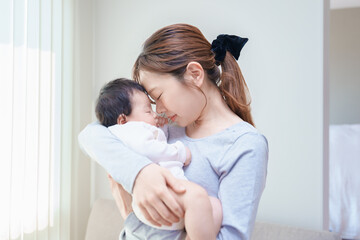 赤ちゃんを抱いて祈るような表情の女性