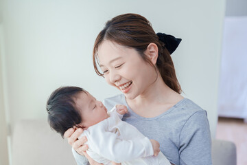 赤ちゃんを抱いて微笑む女性