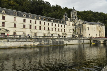 L'imposante bâtisse de l'ancienne abbaye actuellement l'Hôtel de Ville le long des eaux miroitées de la Dromme à Brantôme en Dordogne 