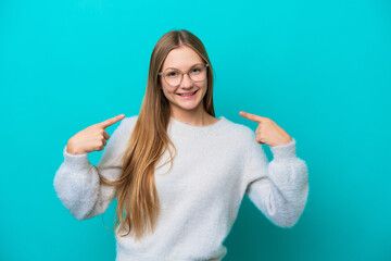 Young Russian woman isolated on blue background giving a thumbs up gesture