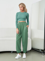Fashionable female model in stylish loungewear poses gracefully in a modern studio setting