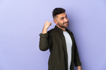 Caucasian man isolated on purple background pointing to the side to present a product