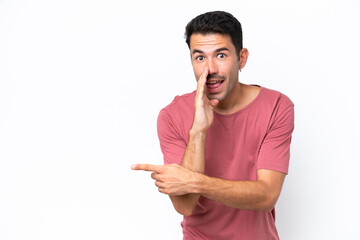 Young handsome man over isolated white background pointing to the side to present a product and...
