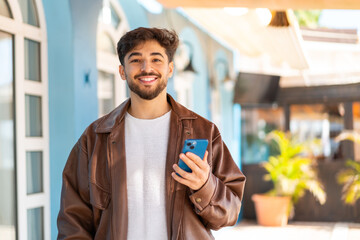 Handsome Arab man at outdoors using mobile phone