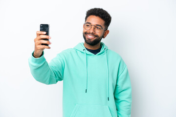 Young Brazilian man isolated on white background making a selfie