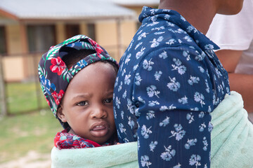piggyback african woman carry child traditional way in a towel in the back