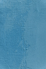 A wall with a blue color and a rough texture. The wall has a few scratches and marks.