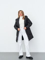 Elegant woman showcases winter fashion in a stylish studio setting during daylight
