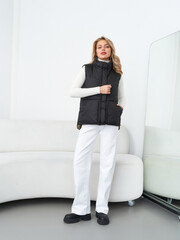 Confident female model showcases contemporary fashion in a stylish studio setting