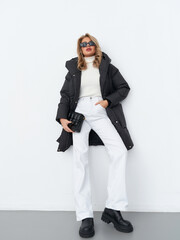 Stylish female model showcases modern fashion looks in a studio setting