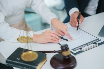 Lawyers Reviewing Case: A male and female lawyer collaborate intently on a case, reviewing documents in a modern, well-lit office. Their focused expressions reflect the seriousness of the situation.
