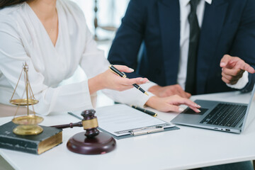 Lawyers Reviewing Case: A male and female lawyer collaborate intently on a case, reviewing...