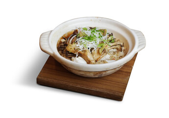 Traditional Japanese donabe clay pot rice with mushrooms and garnish, served on a wooden tray and isolated