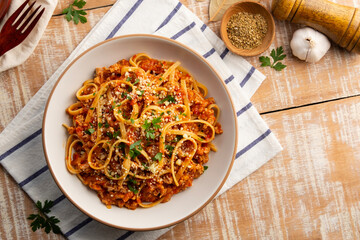 Homemade fettuccine spaghetti with Ground meat and tomato, pasta with a meat based bolognese tomatoes,served on white plate with parmesan cheese.Top view.