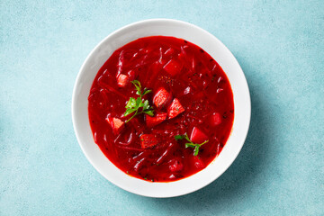 Borsch, beetroot soup in a bowl. Blue background. Close up.