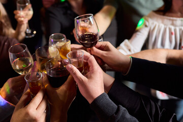Elegant and Stunning Cocktail Glasses Clinking Together in a Softly Dimly Lit Bar Setting