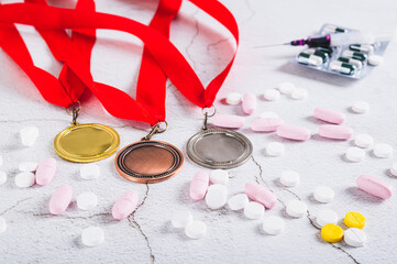 Concept of doping in sports, medals, pills and syringe on the table