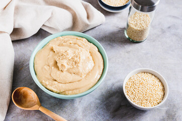 Homemade sesame tahini in bowl on grey table