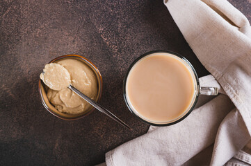 Close up of tahini latte with sesame spread in a cup on the table top view