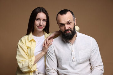 Obraz premium Portrait of happy daughter and father on brown background
