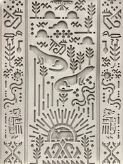 Close up of random ethnic and traditional pattern carved on a grey wall. Resembling ancient Egyptian hieroglyph texture. Ancient tribal art and wall decoration. Seamless background texture.