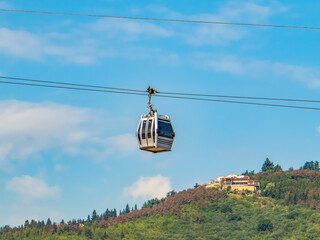 Modern cable cars moving above Tbilisi, Georgia, with a scenic panoramic view of the city.