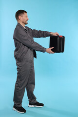 Man holding plastic canister on light blue background