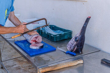 Swordfish (xiphias glades) for sale at fish market in Croatia, large piece of fish on cutting board.