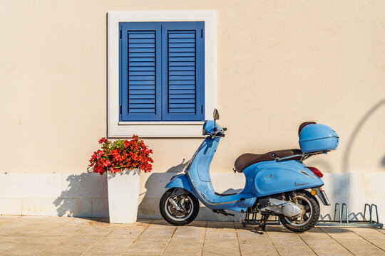 old light blue scooter in front of a house
