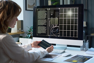 Caucasian female industrial designer sitting in office in front of computer with technical...