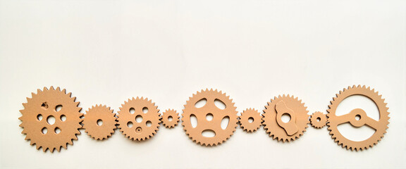 Cardboard gears interlocked on light surface, creative design concept